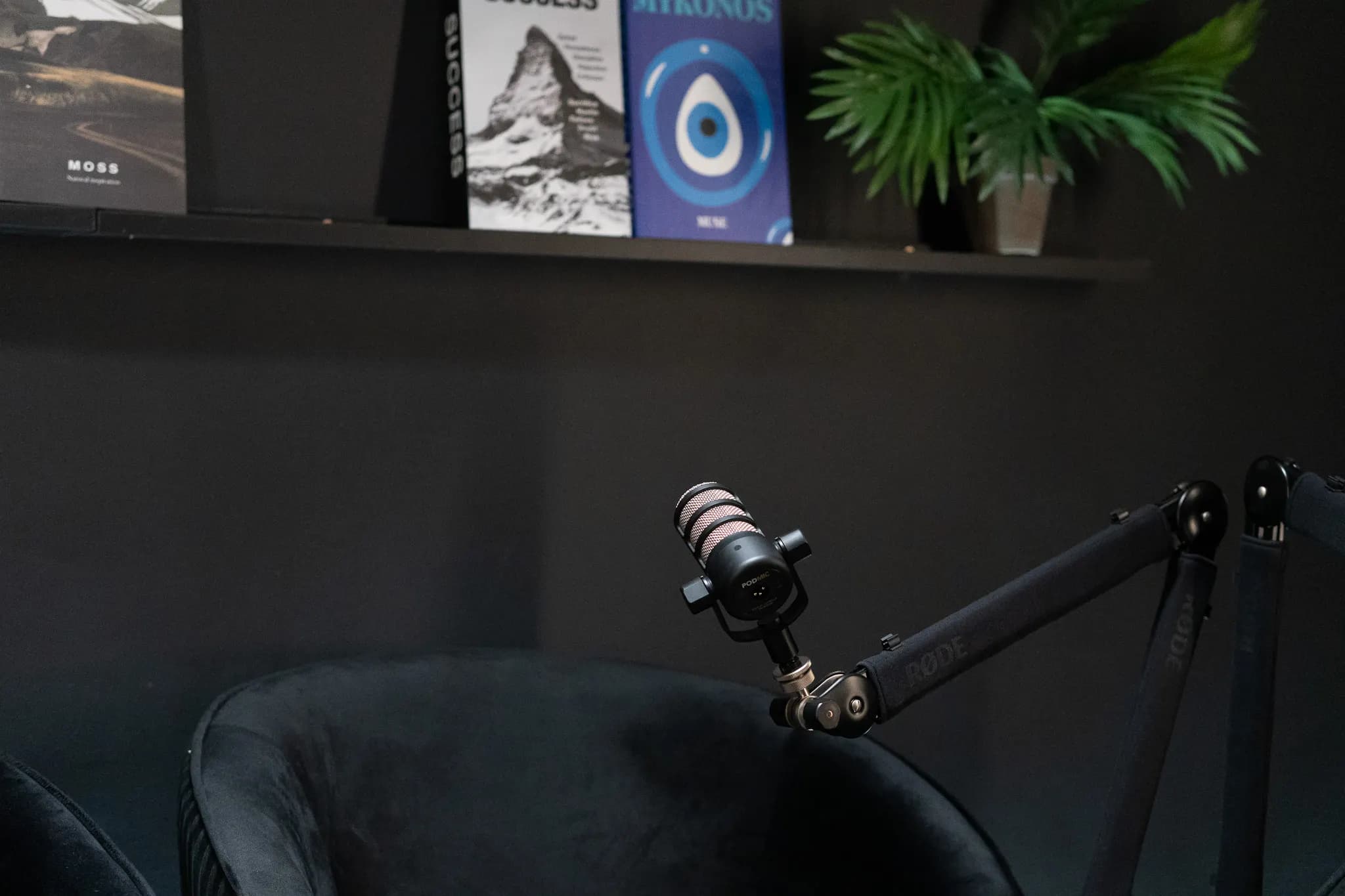 Noir Lounge: mikrofon karon a fekete fotel fölött, könyvek a polcon