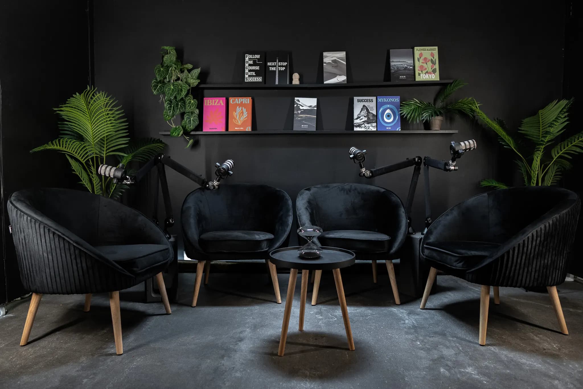 Noir Lounge: négy fekete kagylófotel kerek asztal körül, mikrofonokkal