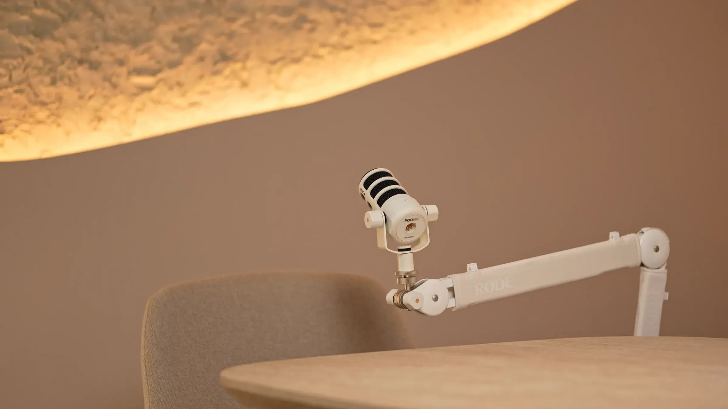 Babyccino Room: fehér mikrofon karon az asztal fölött, hullámos, megvilágított mennyezet