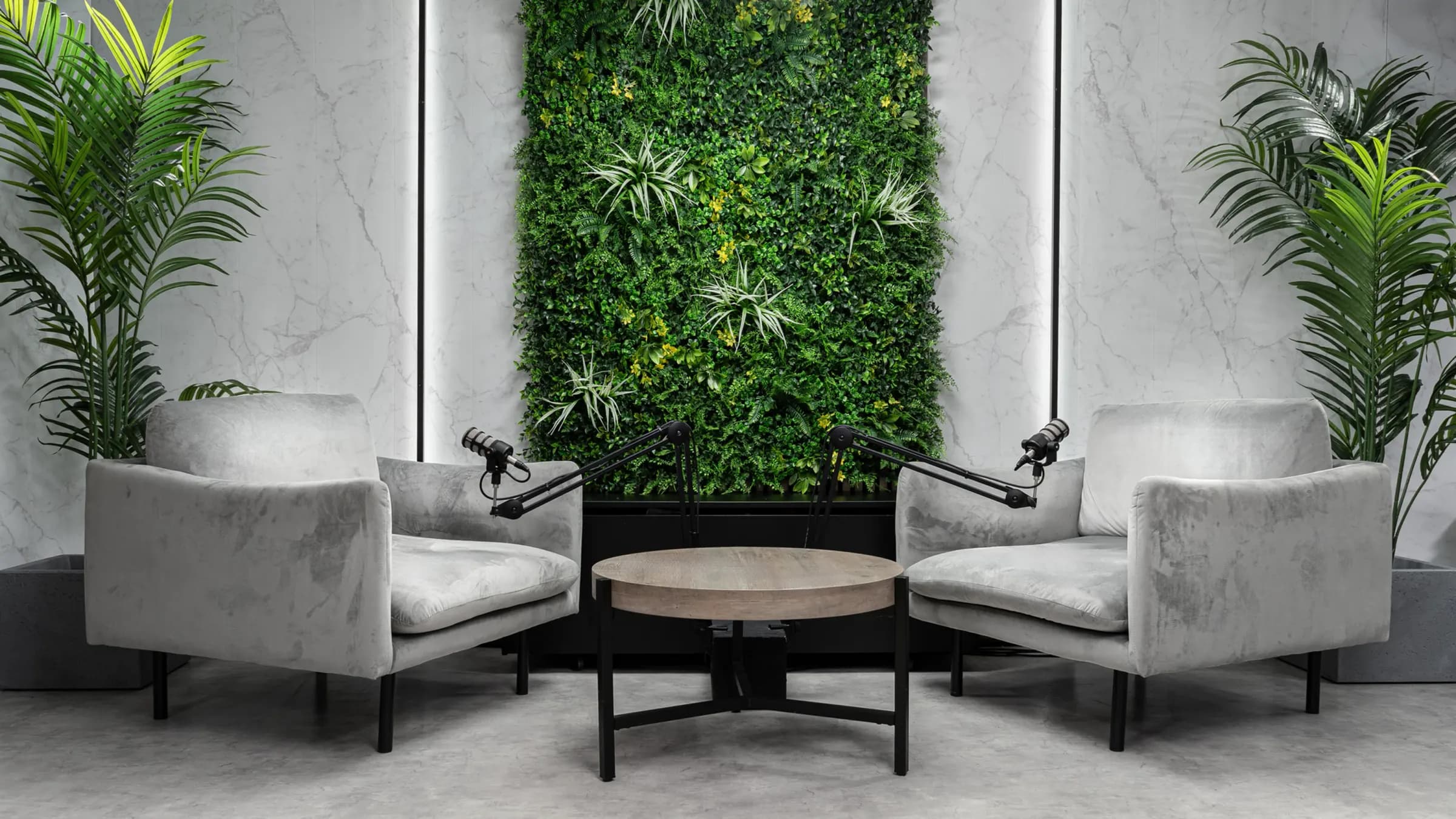 Botanic Suite: két világosszürke bársonyfotel, zöld növényfal, márványmintás falak, pálmák
